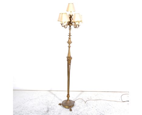 A cast brass six light floor standing candelabra, fitted with five branches, lion paw feet, height 173cm overall.Footnote: So