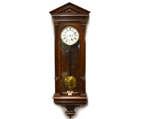 A walnut Vienna-type wall clock, moulded architectural pediments, glazed door, circular enamelled dial with Roman numerals, t