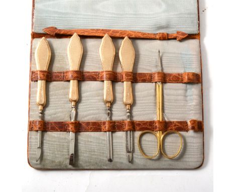 A 9 carat yellow gold part manicure set, four items having engine turned handles hallmarked London 1929, a pair of gilt metal