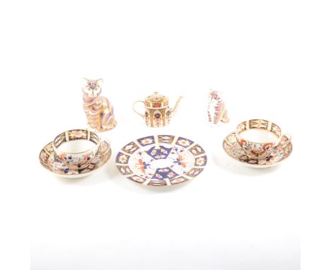 A Royal Crown Derby bone china toy teapot, Imari pattern, damaged, 9cm; two Derby cat and kitten paperweights; two Derby cups
