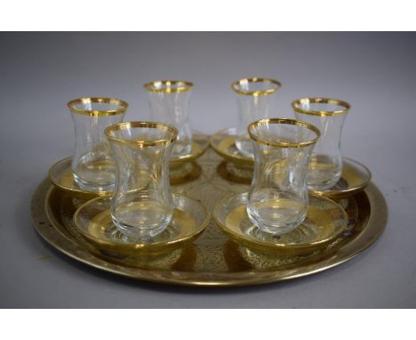 A Circular Brass Islamic Tray together with Six Etched Glasses and Six Moulded Saucers.