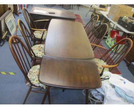 A vintage Ercol dark stained dinging table with table extension and six chairs 