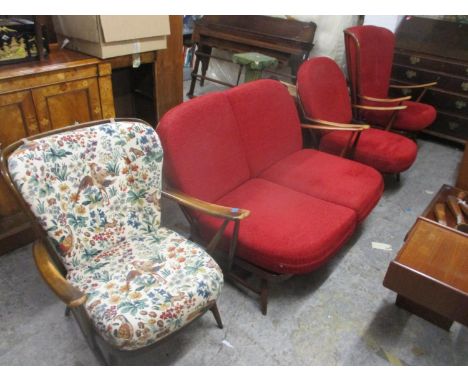 A vintage Ercol dark stained sofa together with three armchairs 