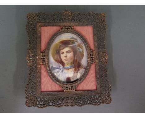 A miniature portrait of a young lady wearing a hat in an oval frame surrounded by a rectangular pierced frame - 15cm x 12cm