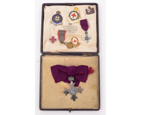 A George V MBE , London 1918, together with miniature and a group of Red Cross enamel service badges, together in a leather M