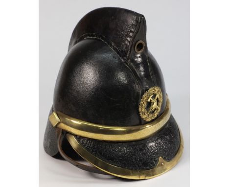 An Edwardian leather Merryweather pattern Fireman's helmet: with brass crossed axe badge, solid comb, brass diamond rosettes,