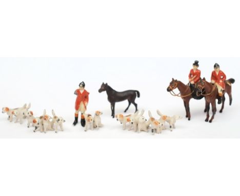 A cold painted miniature hunting group:, comprising huntsman and huntswoman on horseback Master of hounds and three packs of 