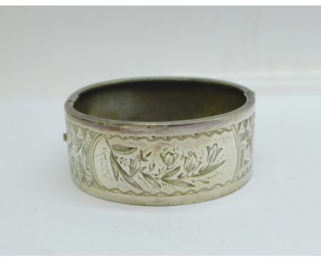 A Victorian white metal bangle with etched decoration 