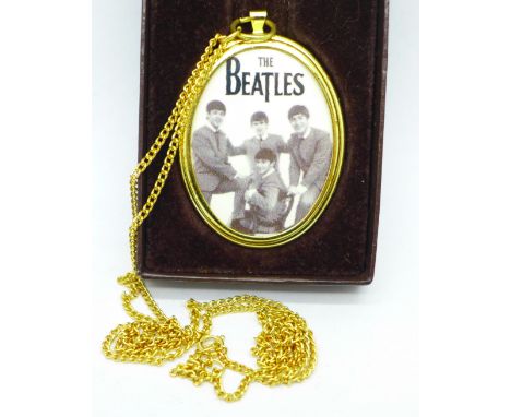 A Beatles picture pendant with chain and a box 