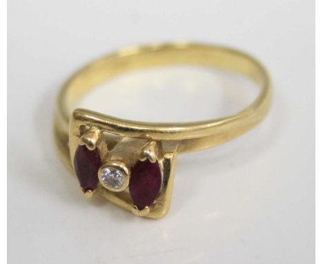 A contemporary yellow metal, ruby and diamond dress ring, arranged as two marquise cut rubies flanking a centre brilliant cut
