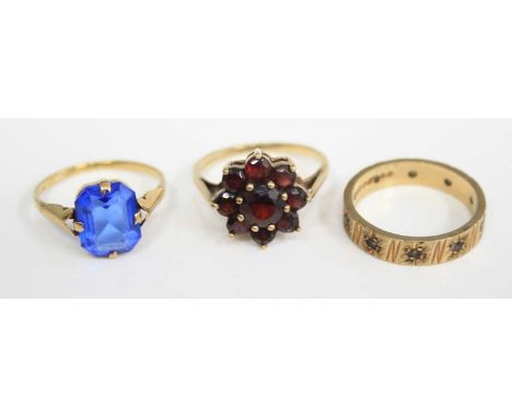 A lady's 9ct gold garnet set flower head cluster ring; together with a 9ct gold blue paste set dress ring; and a 9ct gold whi