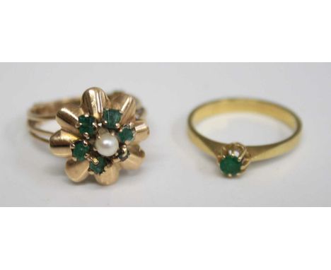 A yellow metal emerald solitaire ring, the round cut emerald weighing approx 0.14 carats, to a plain band, unmarked but tests