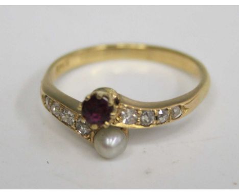 A yellow metal, ruby, cultured pearl, and diamond set dress ring, the ruby and pearl in a crossover setting, the shoulders ea