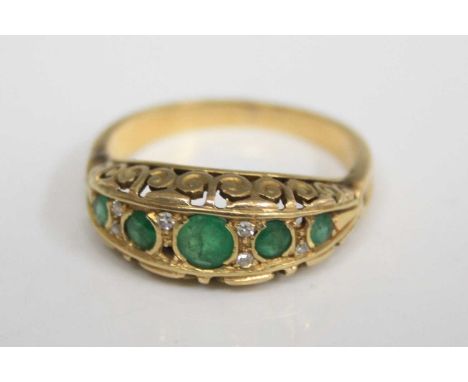 An Edwardian style yellow metal, emerald and diamond highlight set half hoop ring, the graduated round cut emeralds each disp