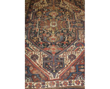 A Caucasian rug with central medallion on a blue ground, within a cream field and triple cream and blue banded floral decorat