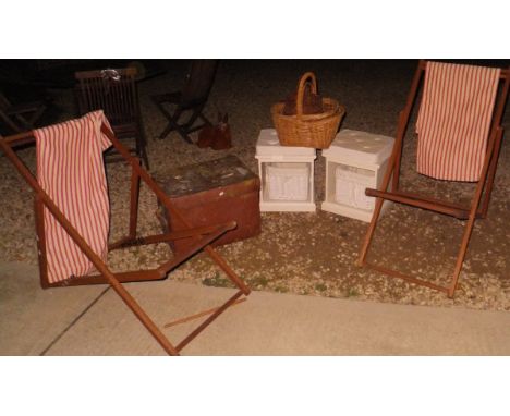A pair of deck chairs, a pair of white units with baskets beneath, three further baskets and a brown hat box style trunk