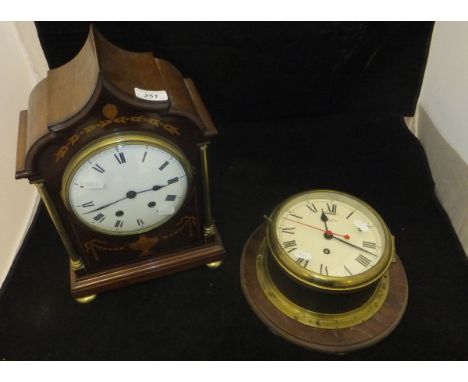 A mahogany cased and inlaid mantle clock with brass column supports, the circular dial with Roman numerals, the eight day mov