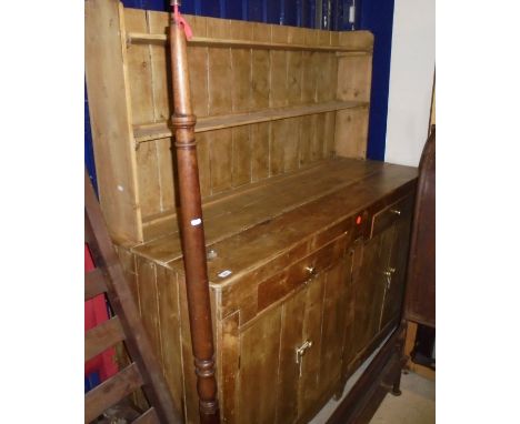 A Victorian pine dresser, two tier plate rack over two drawers and four cupboard doors upon bracket feet