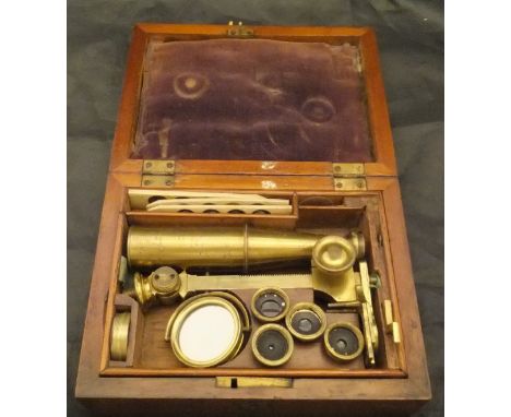 A Victorian lacquered brass monocular microscope on integral stand with various optics, one cover bearing name "E G Wood 74 C