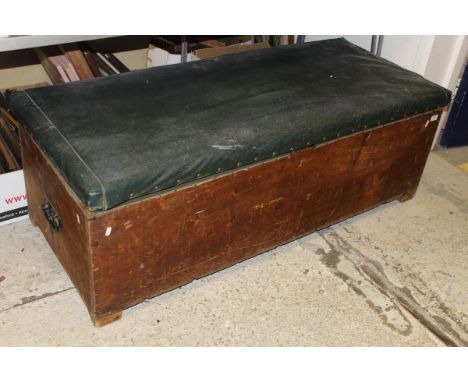 A pine ottoman with leather top containing various curtains, material, etc