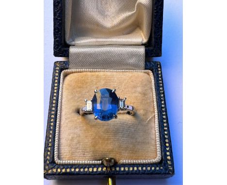 A certified natural 3.09 carat Sri-Lankan sapphire &amp; diamond  ring, the oval four-claw set sapphire flanked by two small 
