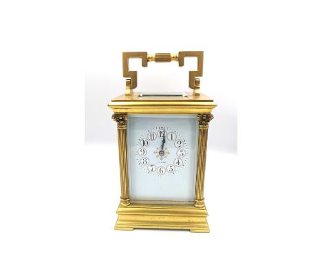 A brass carriage clock, C.1900 marked Dundee to the enamel face with Arabic numerals flanked by Corinthian columns. H.14.2cm 