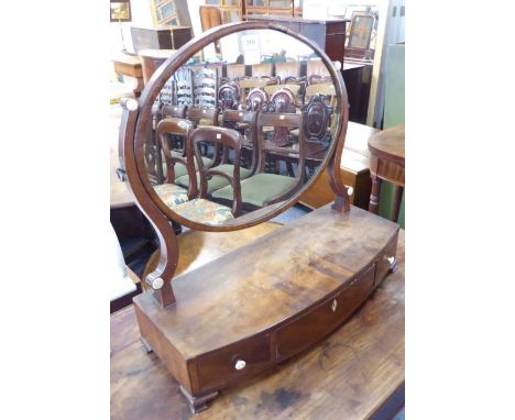 An early 19th century bow-fronted mahogany toilet mirror; three frieze drawers and raised on ogee-style bracket feet (57cm wi