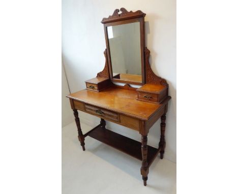 A late 19th century pitch pine dressing table; the central mirror flanked by two further smaller drawers and the base section