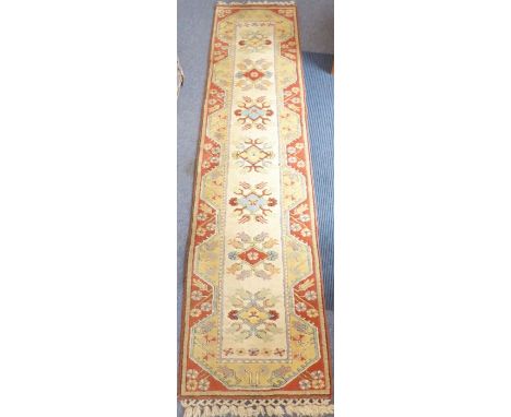 A hand-knotted Hamadan-style runner; central cream rectangle with stylised differing coloured lozenges within segmented light