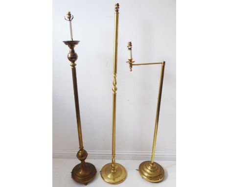 Three brass lamp standards on circular bases (the tallest 150cm high)