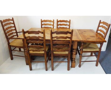 A good extending solid oak dining table in 17th century style (reproduction); the top with single leaf end extension and clea