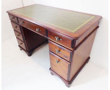 A 19th-century-style (reproduction) stained-pine pedestal desk; green gilt-tooled leather-inset top above an arrangement of e
