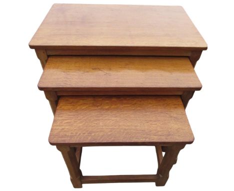 Robert Mouseman Thompson - nest of three oak rectangular tables, with adzed tops on faceted supports joined by stretchers, ca