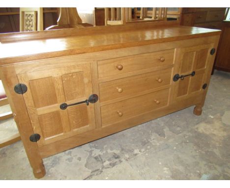 Robert Mouseman Thompson - oak sideboard, adzed top with raised back above three drawers with turned wooden handles enclosed 