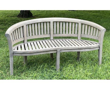 BANANA BENCH, silvery weathered teak with arched back and arms of slatted construction, 160cm W. 