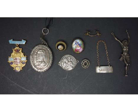 A white metal locket, the obverse with cross, IHS and winged cherub masks, the reverse with bust of gentleman, H.5.5cm, toget