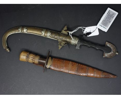 Two early 20th century Caucasian daggers, from Armenia, to include one curved dagger with white metal and copper scabbard, H.