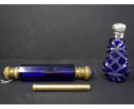 A blue cut glass scent bottle with silver top, H.9.5cm, together with a blue glass and brass topped double scent bottle, H.15