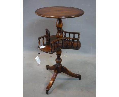 A mahogany lamp table with round top above revolving undertier with turned rails, on three legs and castors, H.76cm 