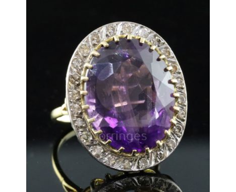 A large gold, amethyst and diamond set oval dress ring, the oval cut amethyst bordered by twenty eight round cut diamonds, si