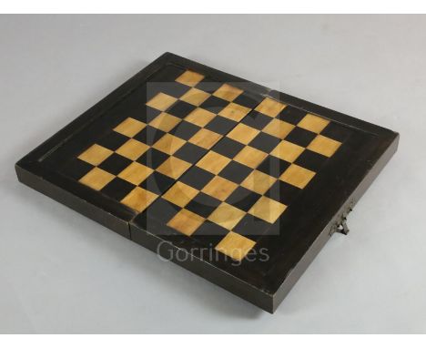 An early 19th century ebony and boxwood travelling games box, with external chess board and internal backgammon, 23 x 13.5in.