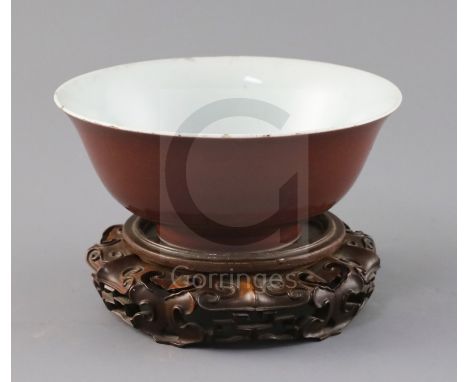 A Chinese copper red glazed bowl, Qianlong seal mark and of the period (1736-95), D. 18.2cm, small rim chips, wood stand