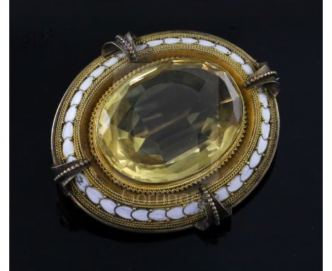 A Victorian gold, white enamel and citrine set oval brooch, the large oval cut stone with gold multi ropetwist and white enam