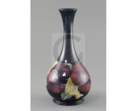 A Moorcroft 'pansy' bottle vase, c.1917, impressed marks Moorcroft Burslem England 50, inscribed in green W.Moorcroft, H.21.7