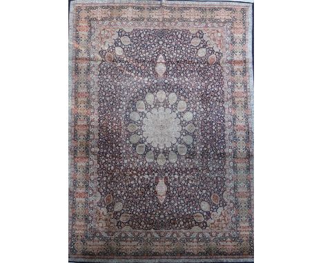 A Kashmir blue ground silk on cotton carpet,&nbsp;with central flower head motif in a field of scrolling foliage, with multi 