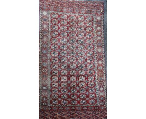 An antique Tekke Bokhara carpet, with field of polygons, on a red ground, with multi row border, 11ft 11in by 7ft 6in.