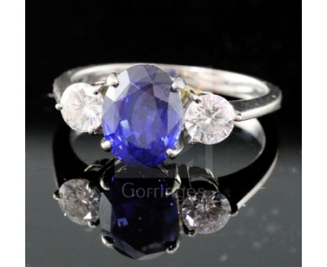 An 18ct white gold, sapphire and diamond three-stone ring, size N.