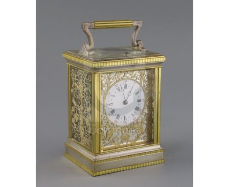 An early 20th century silvered and ormolu hour repeating carriage clock, with enamelled Roman dial and fretwork decorated cas
