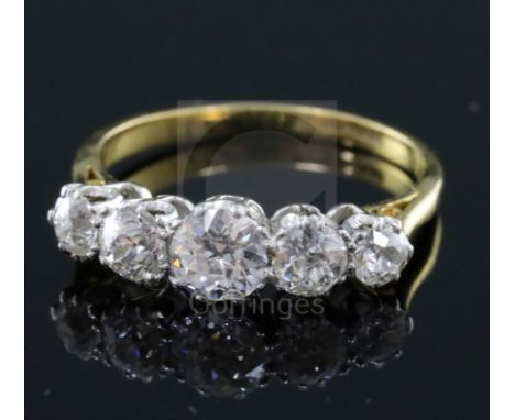 An 18ct gold and platinum, graduated five stone diamond half hoop ring, size M.