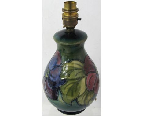 A Moorcroft green ground Clematis pattern lamp of small proportions, bearing Queen Mary label to the underside, height 26cm.